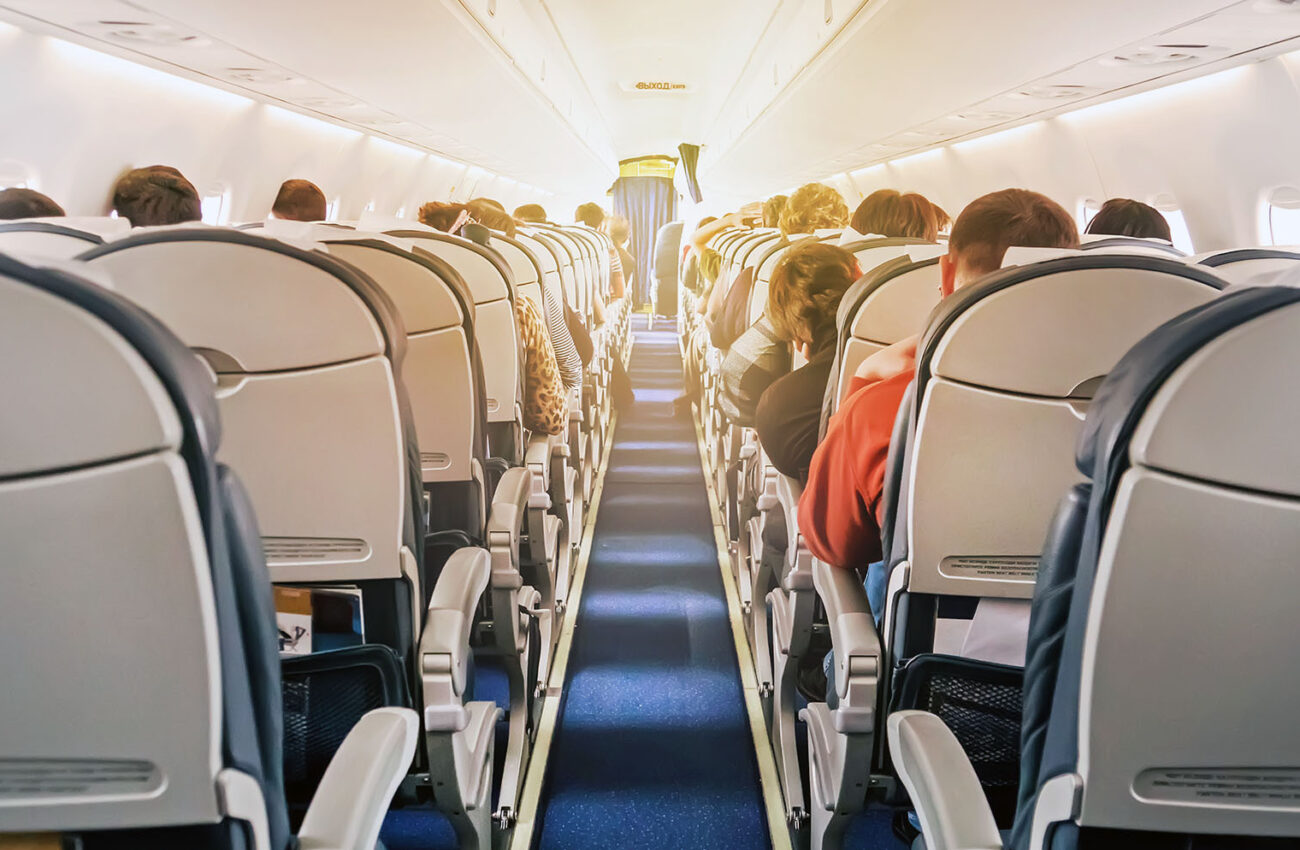 Commercial aircraft cabin with rows of seats down the aisle